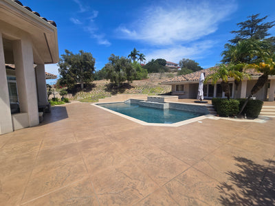 Real pool deck project using a blend that includes Smith's Dark Adobe stain; lighter tan and brown tones across textured concrete.
